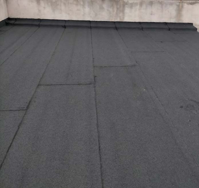 Un techo negro con una pared blanca al fondo