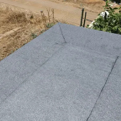 Un primer plano de un tejado con una valla al fondo.