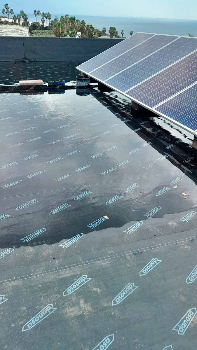 Un techo con paneles solares y vista al océano.