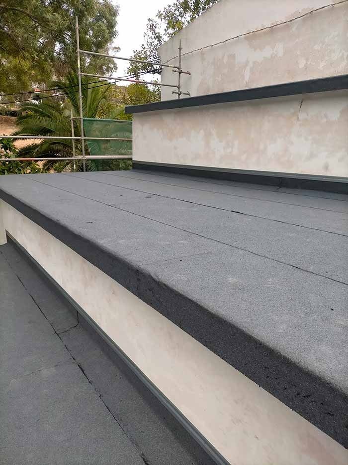 Un primer plano de una escalera con una alfombra gris encima.