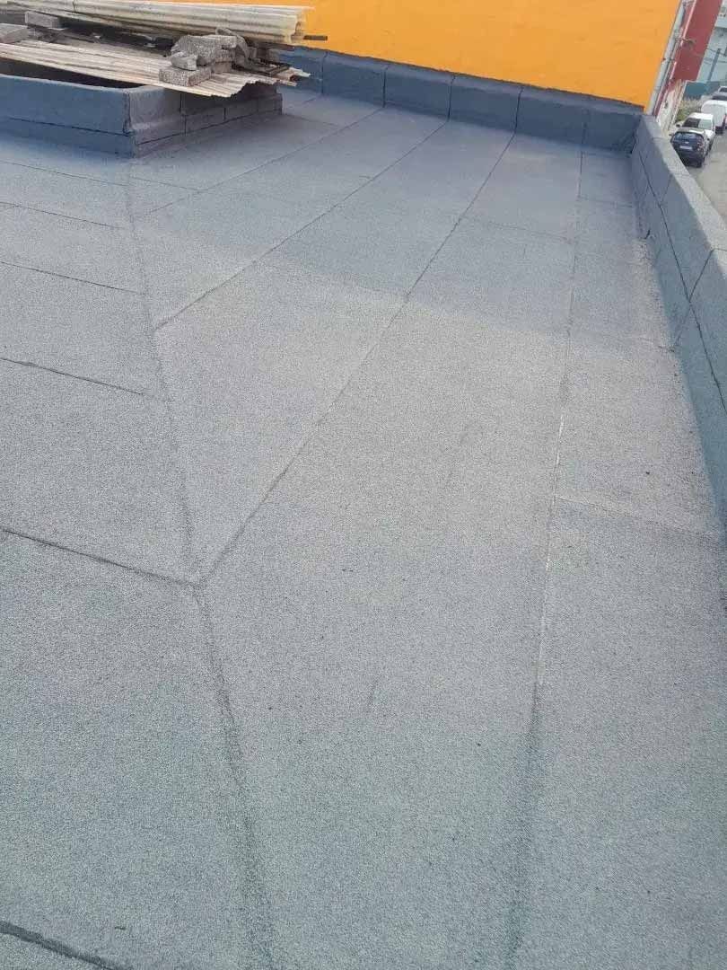 Un suelo de hormigón gris con una pared amarilla al fondo.