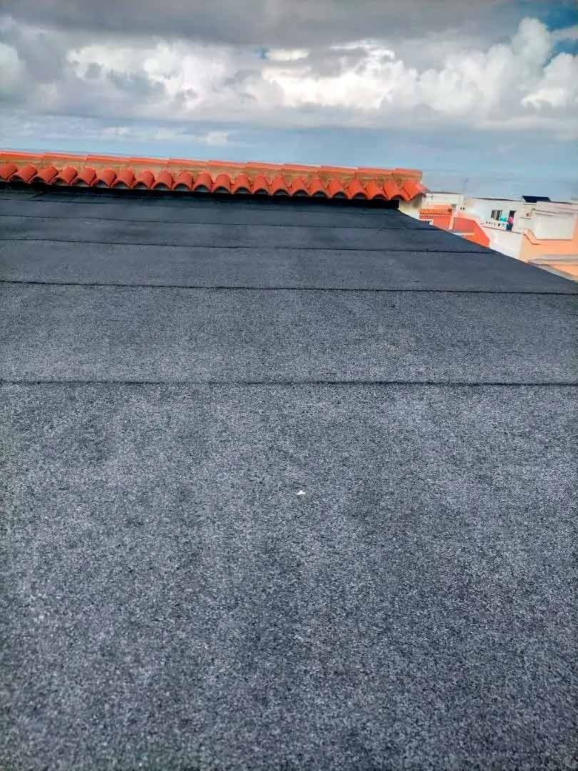 Un primer plano de un tejado con un cielo azul de fondo.