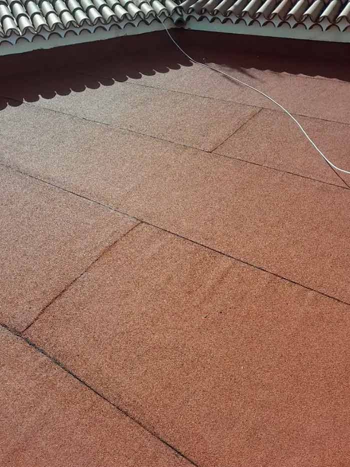 Un primer plano de un techo rojo con un cable blanco colgando de él.