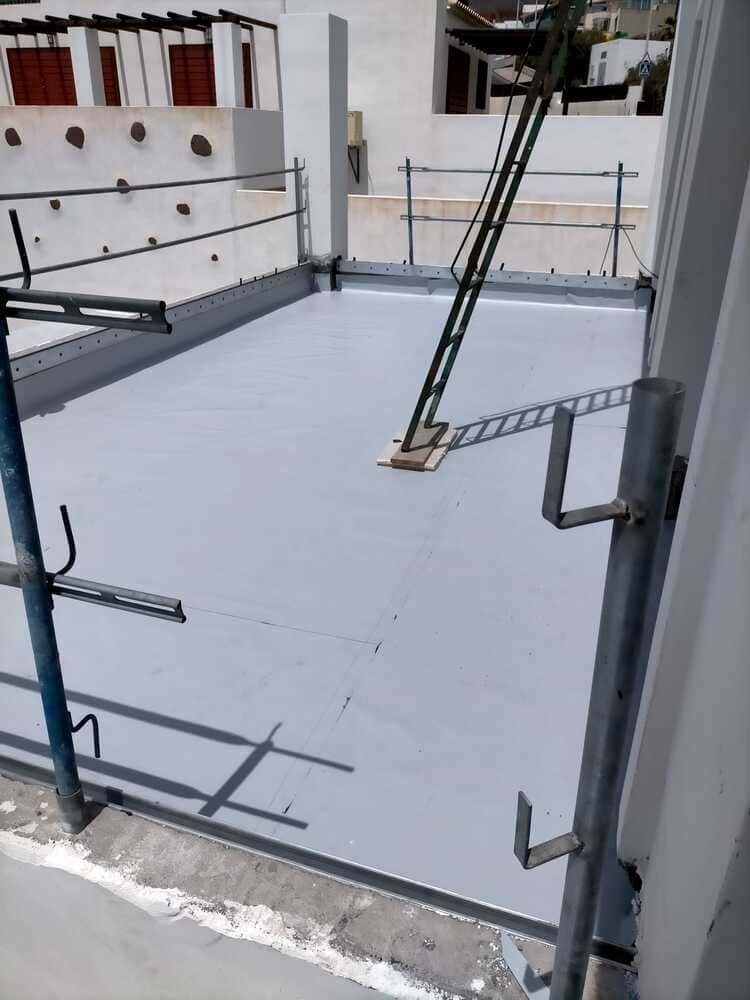 Un techo blanco con andamios y una escalera sobre él.