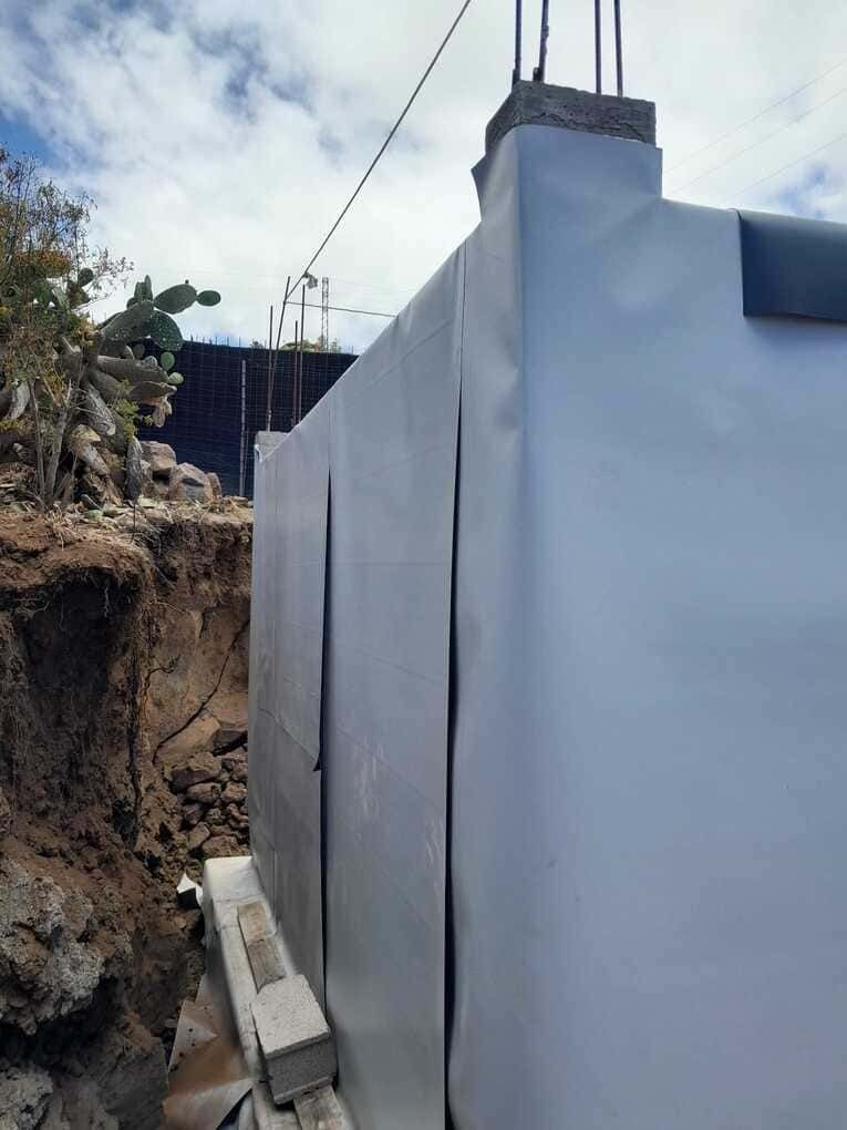 Un gran edificio blanco está situado en la cima de una colina de tierra.