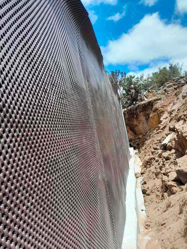 Se está instalando un sistema de drenaje en el lateral de un edificio.