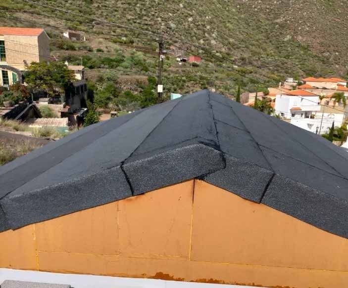 Un primer plano de un tejado con una montaña al fondo.