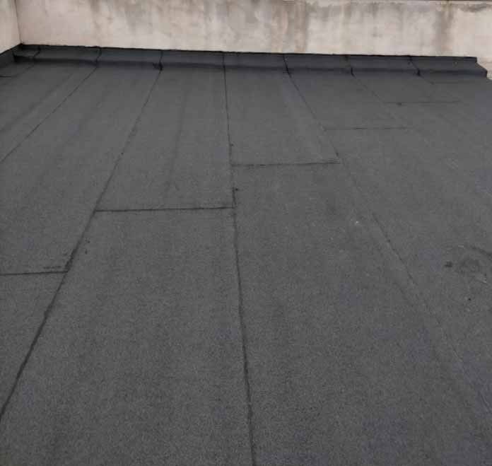 Un techo negro con una pared de hormigón al fondo.