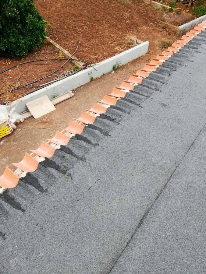 Una fila de sillas naranjas están colocadas al costado de una carretera.