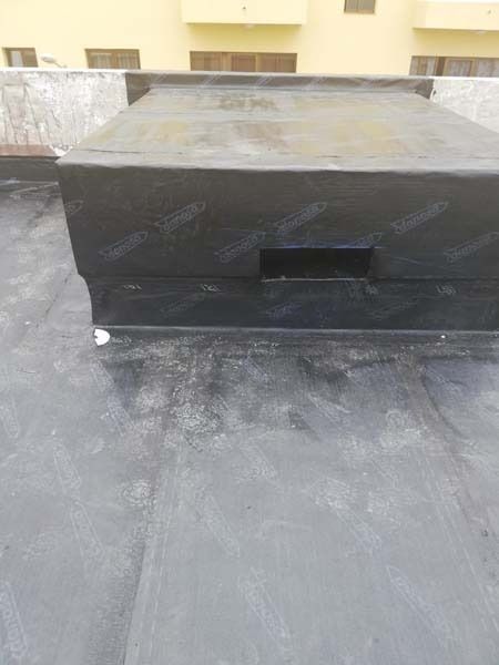 Una caja negra está sentada encima de un techo negro.