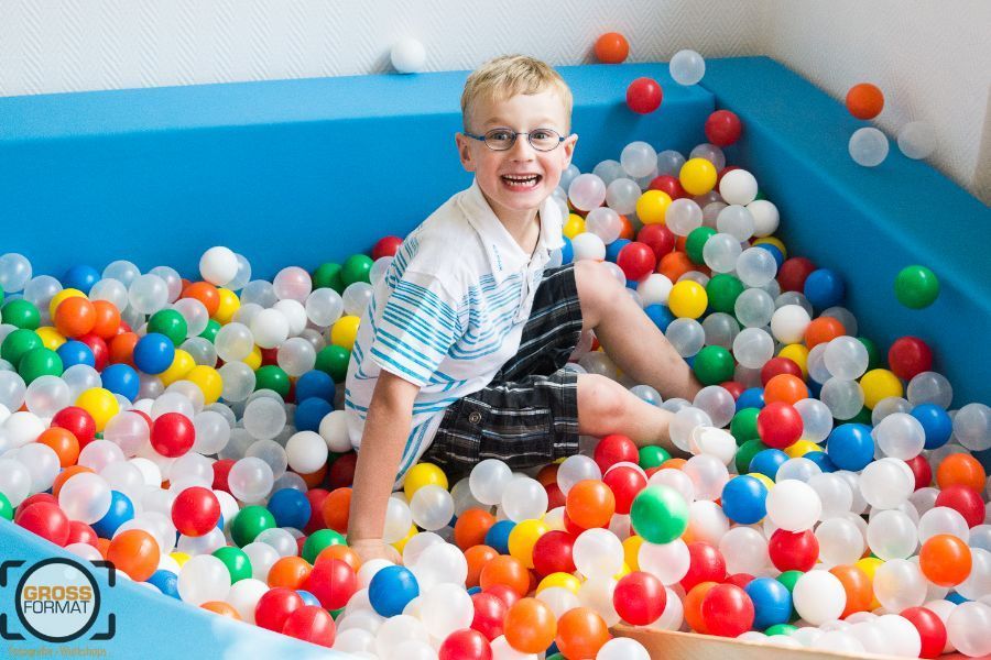 Kind hockt im Bällebad