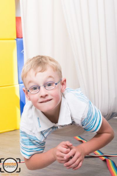 Kind guckt in die Kamera in einem Hängetuch