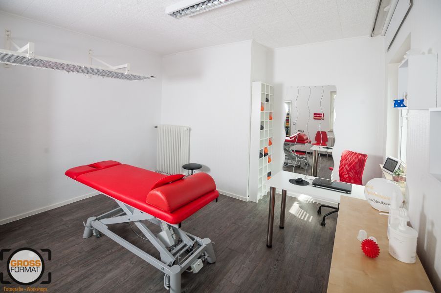 Massageliege in rot in einem Therapiezimmer