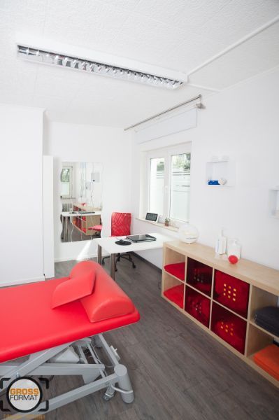 Behandlungszimmer mit roter Liege