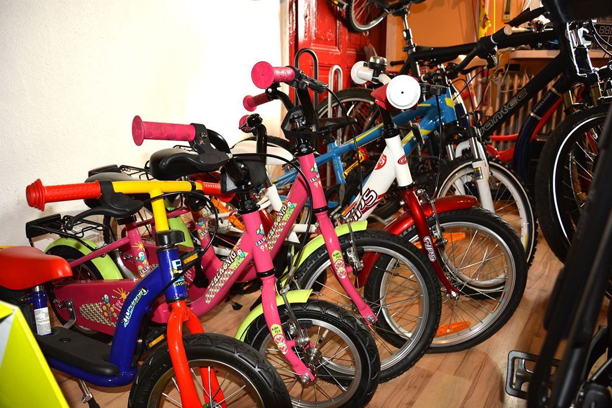 Ein Haufen Kinderfahrräder sind in einem Raum aufgereiht