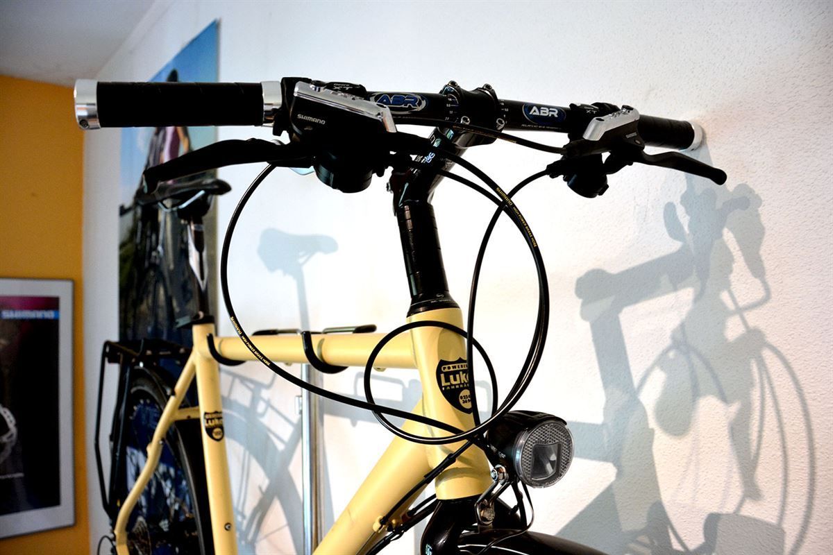 Ein gelbes Fahrrad mit einem Schatten an der Wand
