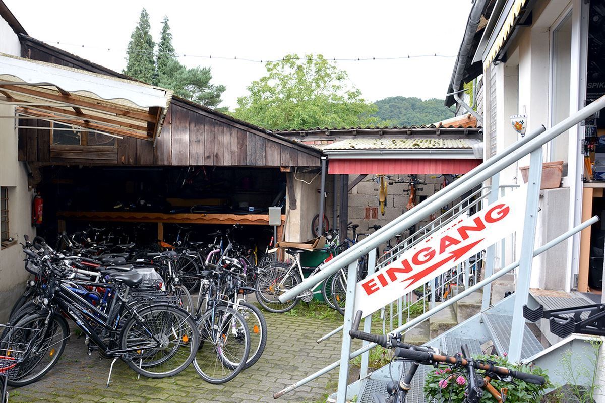 Ein Haufen Fahrräder steht vor einem Gebäude mit einem Schild mit der Aufschrift „Eingang“