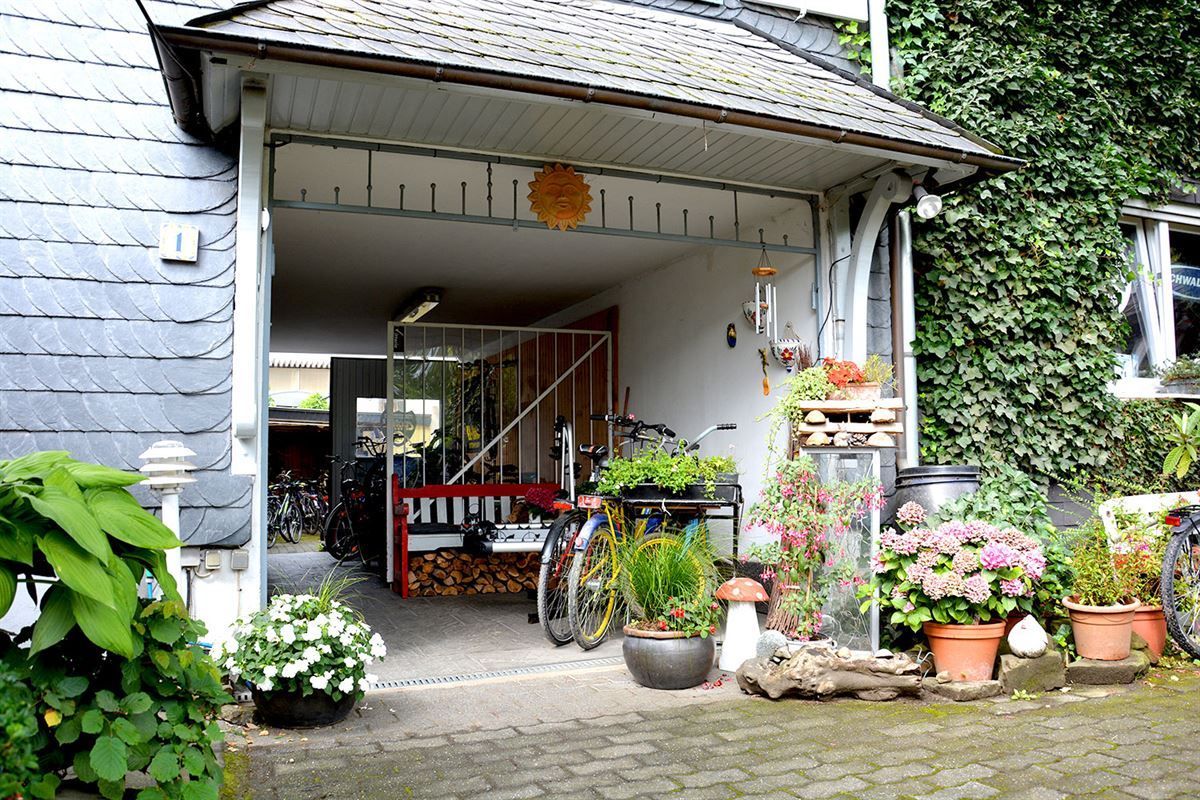 Ein Fahrrad steht vor einer Garage mit Blumen und Pflanzen