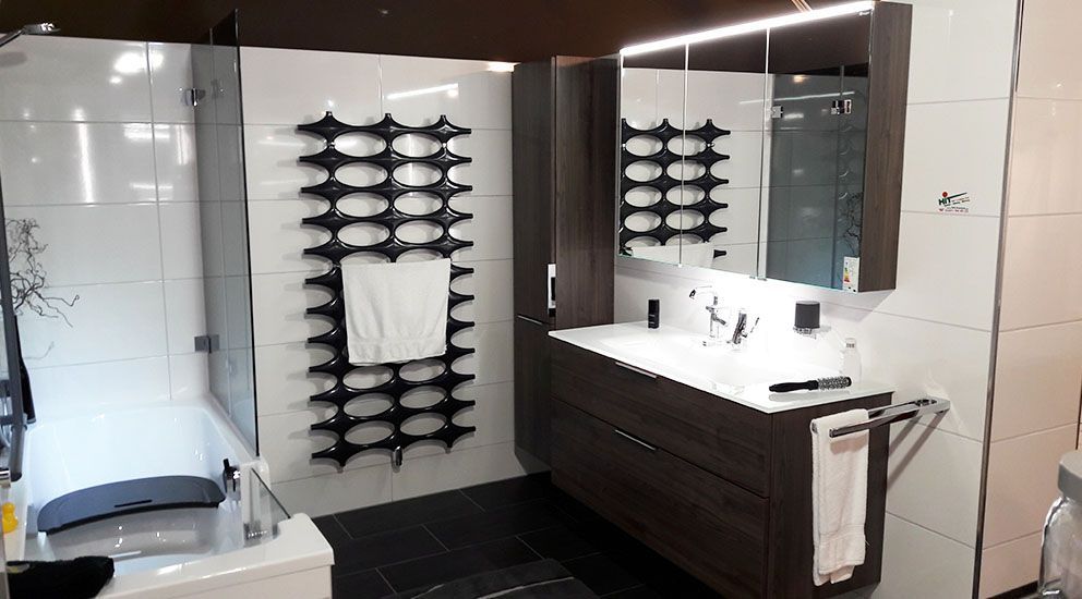 Ein Badezimmer mit Waschbecken, Spiegel und Handtuchhalter.