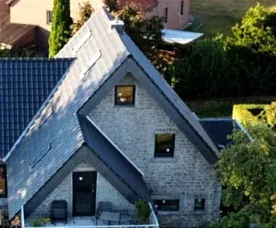 Eine Luftaufnahme eines Backsteinhauses mit blauem Dach