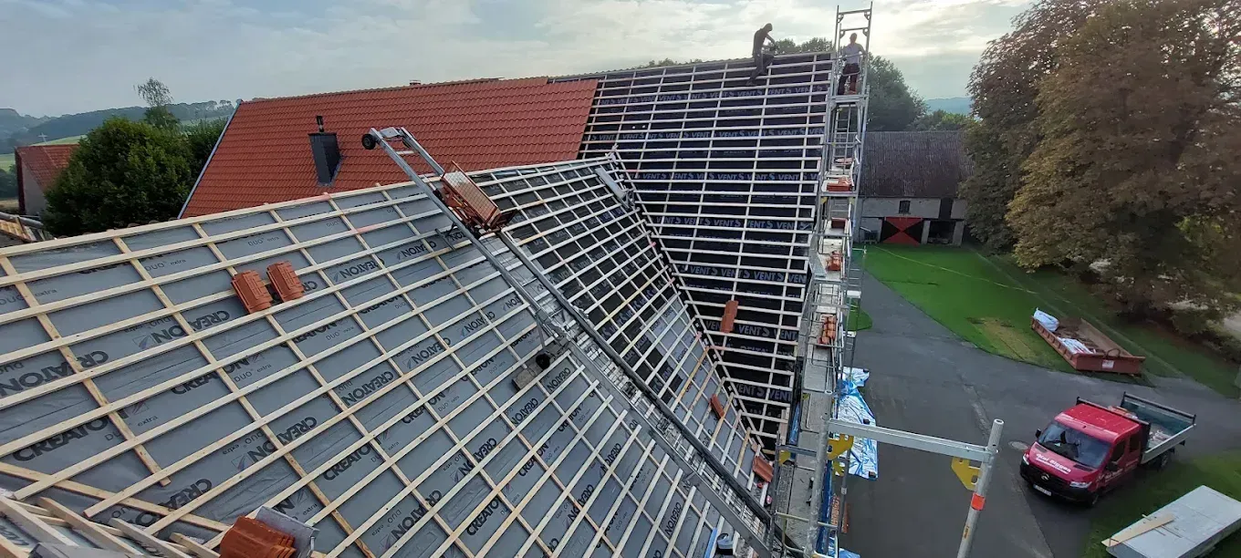 Ein roter Lieferwagen steht vor einem Gebäude im Bau