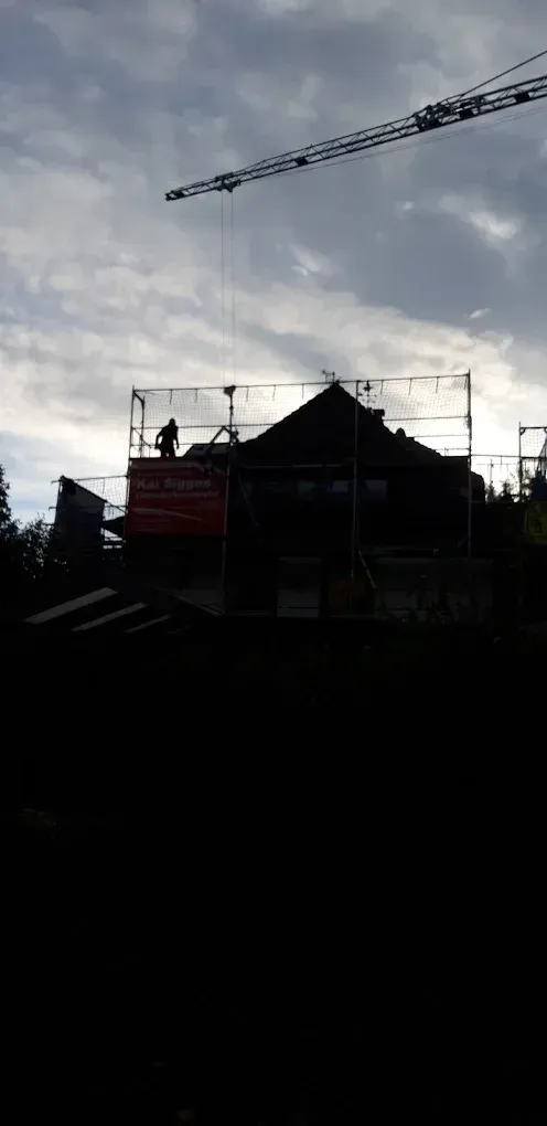 Die Silhouette eines im Bau befindlichen Gebäudes mit einem Kran im Hintergrund