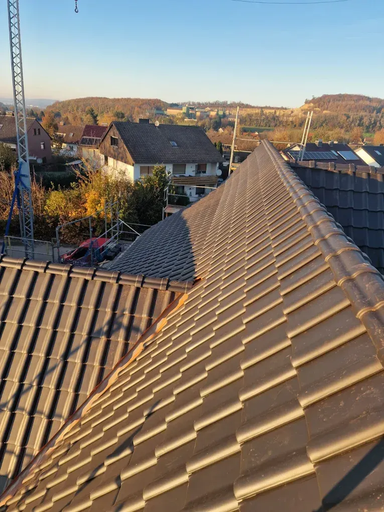 Ein Dach mit vielen Ziegeln und einem Kran im Hintergrund