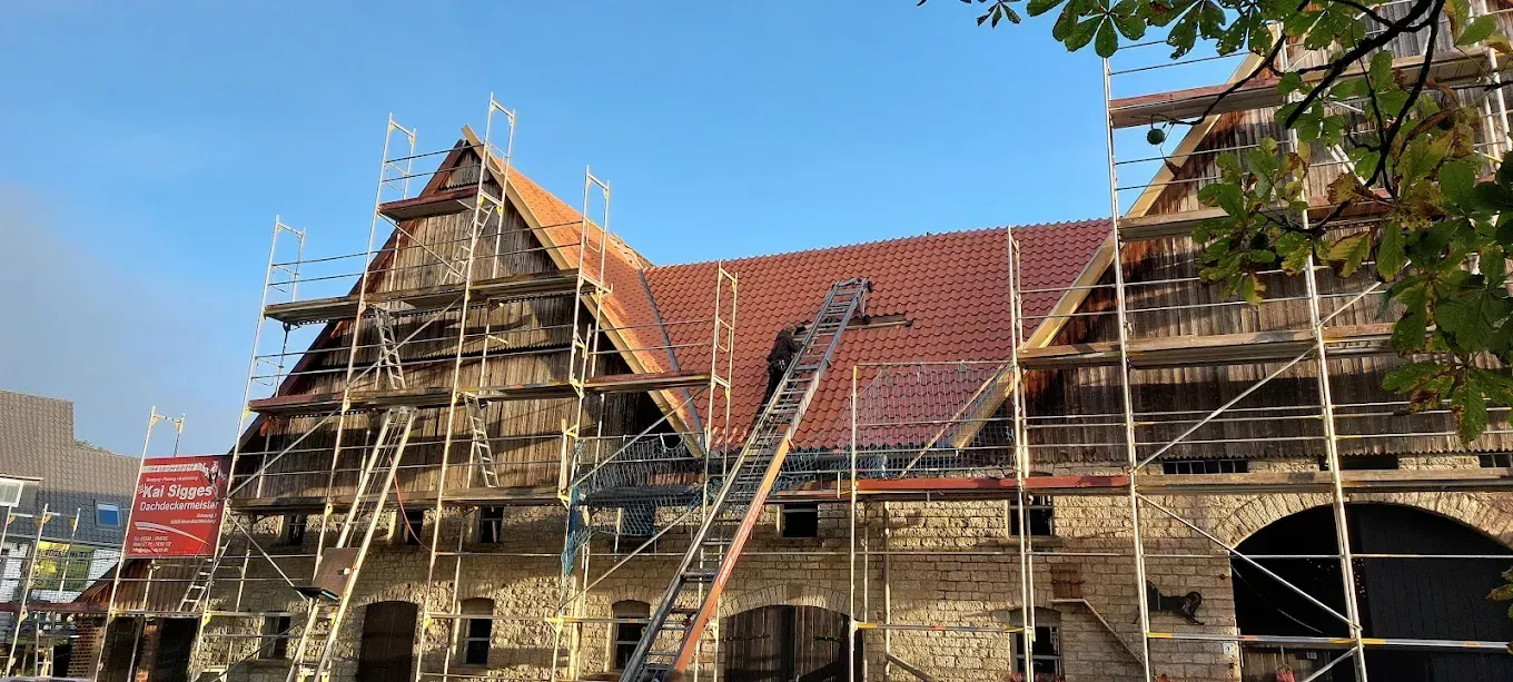 Ein großes Gebäude mit einem Gerüst und einem roten Ziegeldach