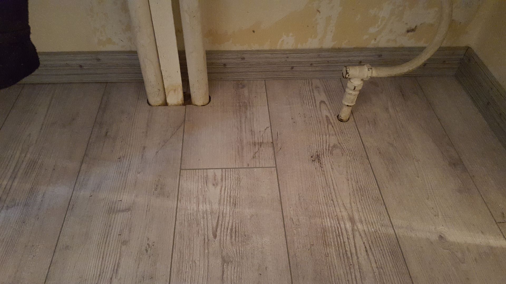 Finition de parquet contre des tuyaux