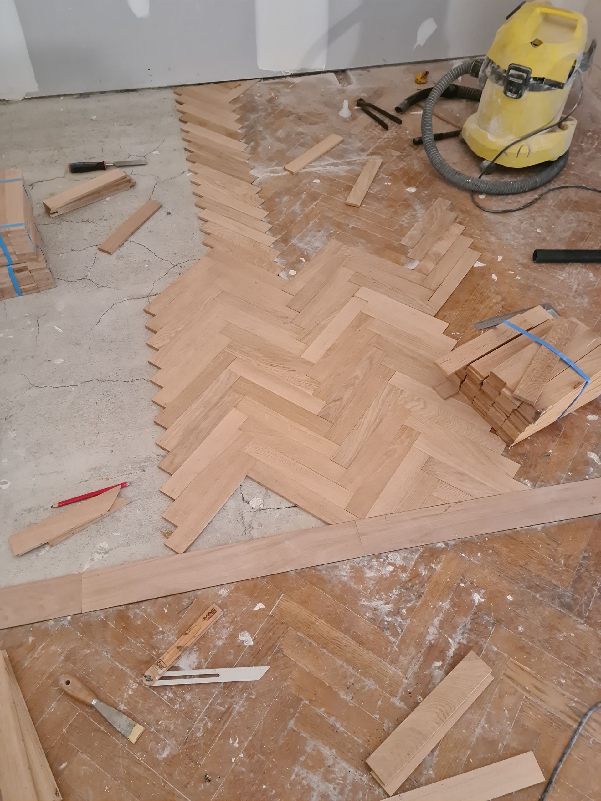 Pose de parquet à bâtons rompus le long d'une baguette de bois