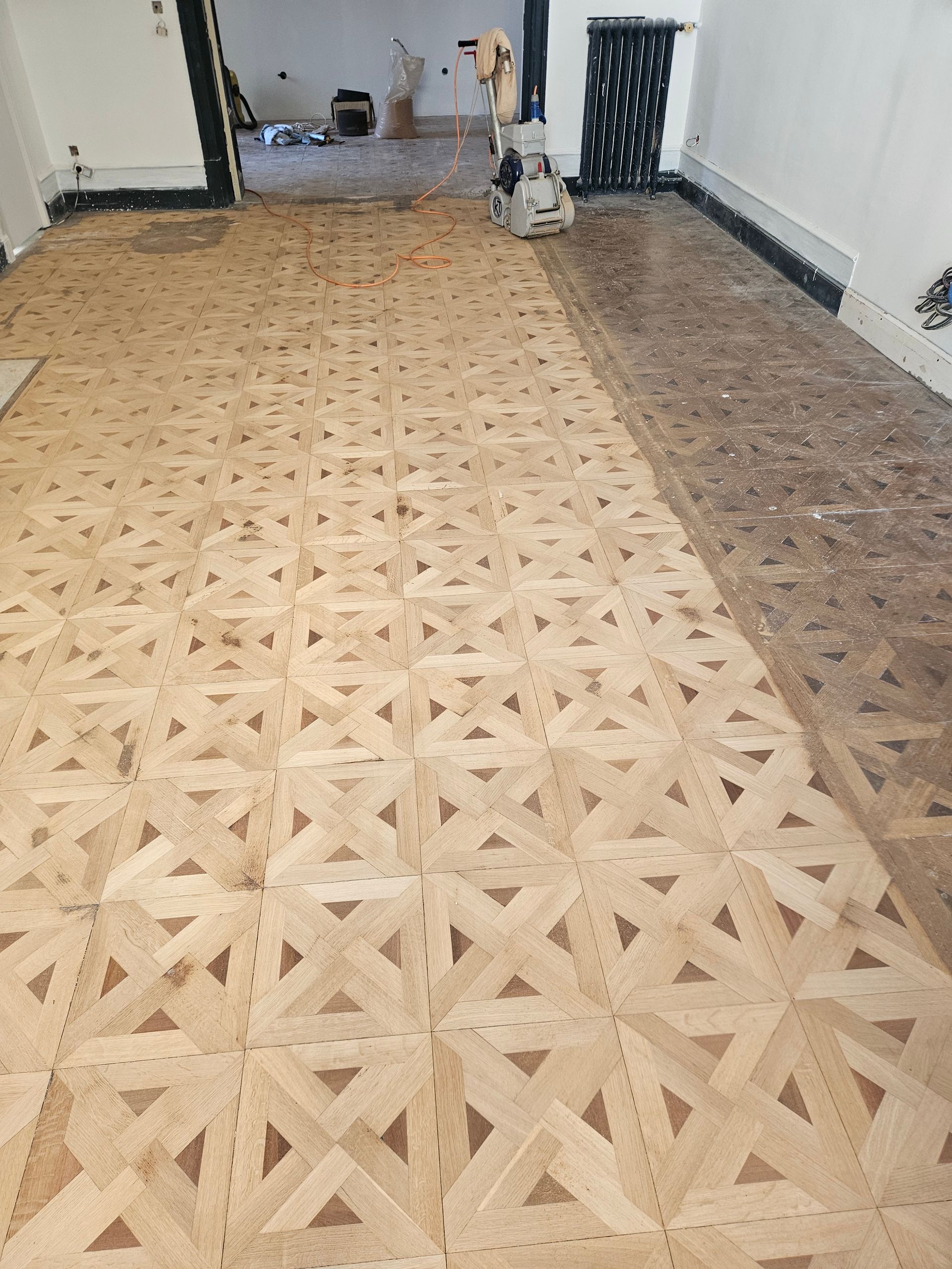 Parquet à panneaux de Versailles en cours de rénovation, à moitié blanc à moitié noir