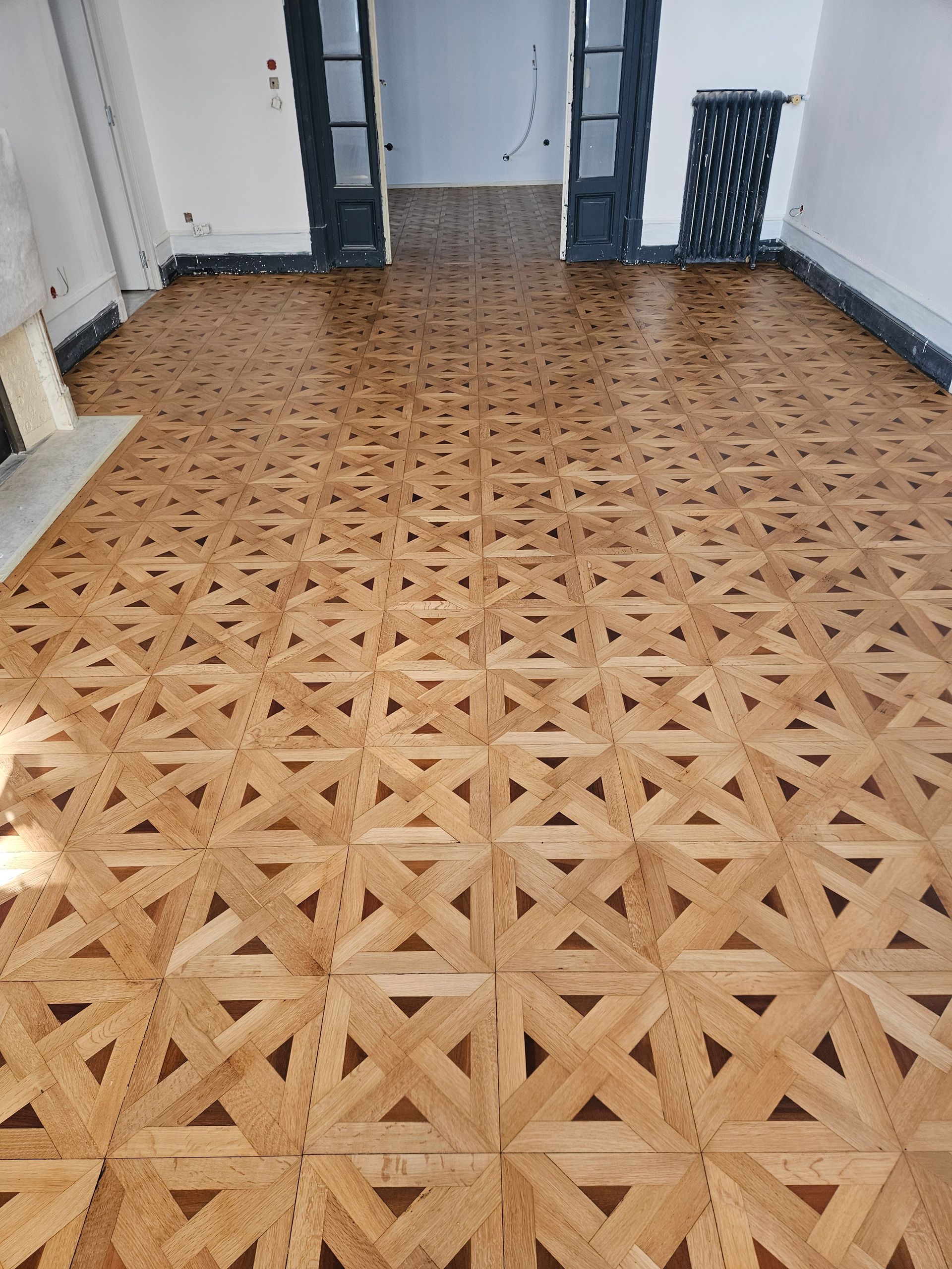 Parquet en panneaux de Versailles rénové dans une grande pièce
