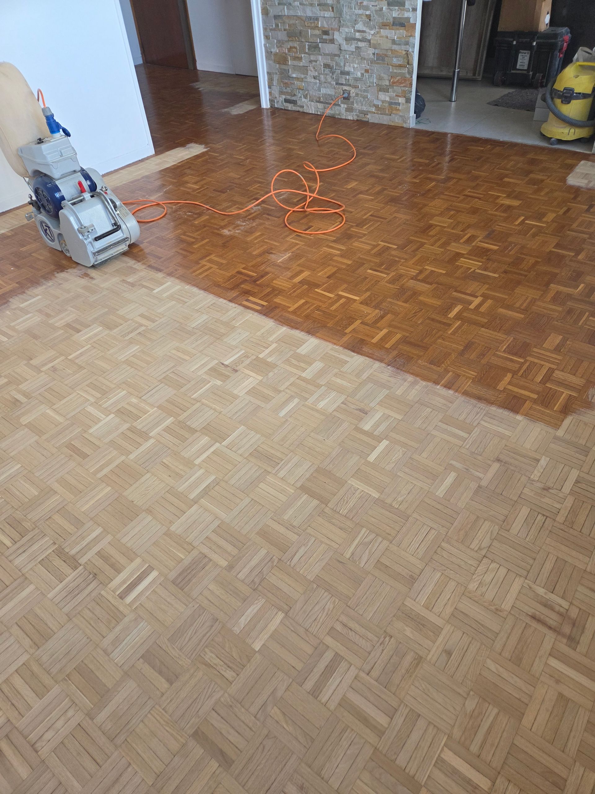Ponceuse professionnelle sur un parquet en mosaïque