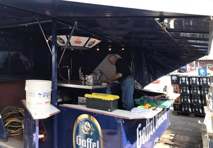 Ein Mann steht hinter einer Theke, auf der „Goffel“ steht