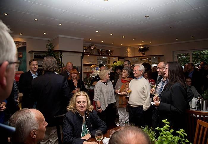 Eine Gruppe von Menschen versammelt sich um einen Tisch in einem Restaurant