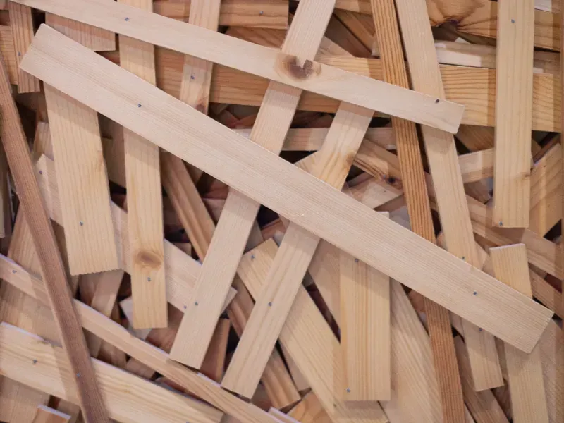 Montón de astillas de madera de color claro y tiras tejidas apiladas en forma de cuadrícula.