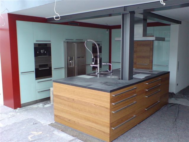 Moderne Küche mit Holzinsel, Geräten aus Edelstahl und Akzenten in Rot und Aquamarin.