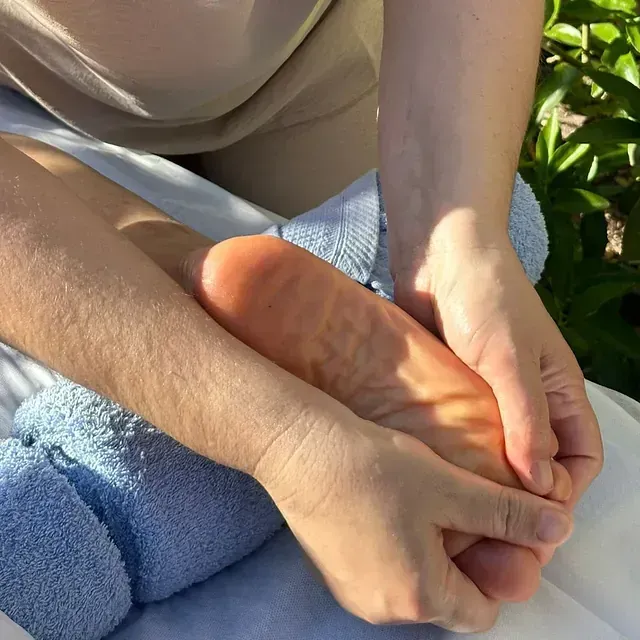 Una persona masajea el pie de otra.