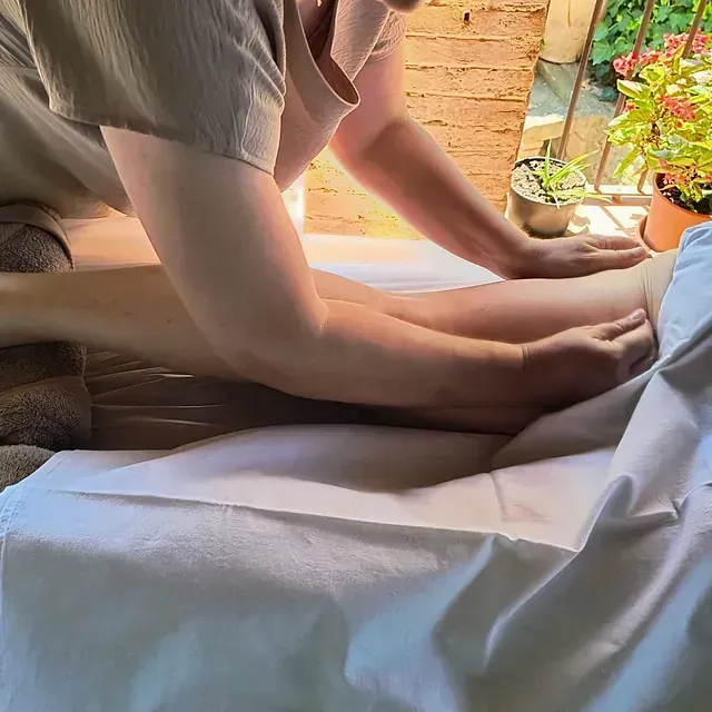 Una persona está acostada en una cama recibiendo un masaje.