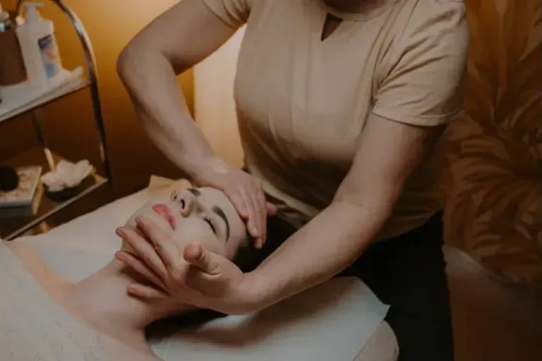 Una mujer está recibiendo un masaje facial en un spa.