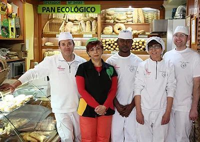 Un grupo de personas posa para una fotografía en una panadería.