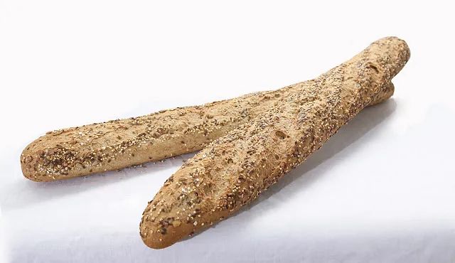 Dos hogazas de pan están colocadas sobre una superficie blanca.