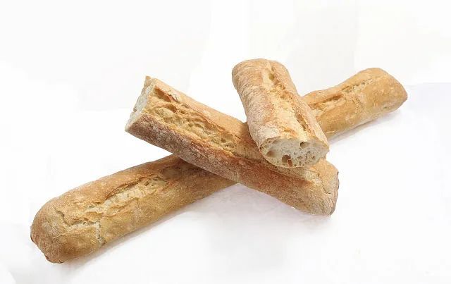 Tres panes cruzados uno sobre otro sobre una superficie blanca.