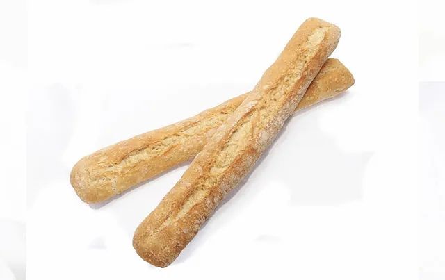 Dos baguettes están colocadas una encima de otra sobre una superficie blanca.
