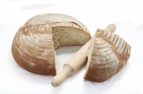 Una hogaza de pan con un rodillo al lado.
