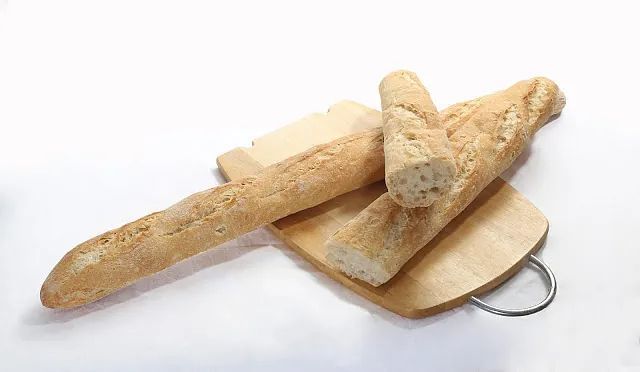 Una hogaza de pan reposa sobre una tabla de cortar de madera.