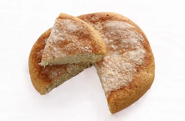 Un pastel con una rebanada extraída sobre un fondo blanco.