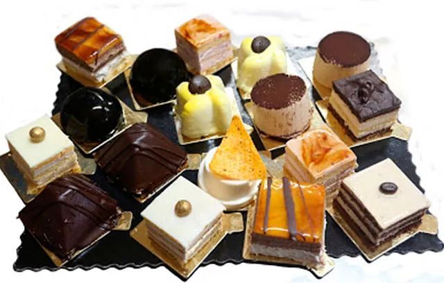 Una variedad de postres están en una bandeja sobre una mesa.