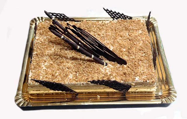 Un pastel en una bandeja con palitos de chocolate encima.