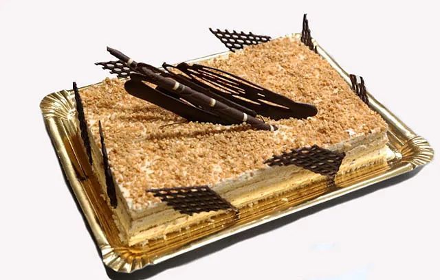 Un pastel en una bandeja de papel con palitos de chocolate encima.